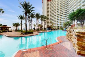 a large swimming pool with palm trees and a large building at Shores of Panama 1318 in Panama City Beach