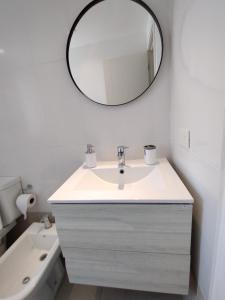 een badkamer met een wastafel en een spiegel aan de muur bij Valle Serrano II Departamentos in Tandil