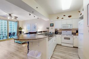a large kitchen with white cabinets and a table at Shores of Panama 1318 in Panama City Beach