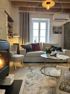 uma sala de estar com um sofá e uma lareira em Le Hameau de la Closerie 