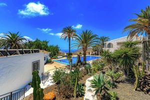a villa with a swimming pool and palm trees at Tropicalidays Oceanview Chayofa in Chayofa