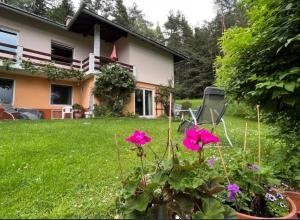 a house with pink flowers in the yard at Ferienwohnung Muthspiel in Keutschach am See