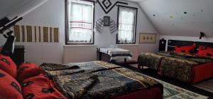 a bedroom with two beds in a room with windows at Casa Lia in Valea Putnei