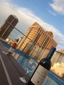 a bottle of wine and a wine glass with buildings at Cosy Apartment in Johannesburg in Johannesburg