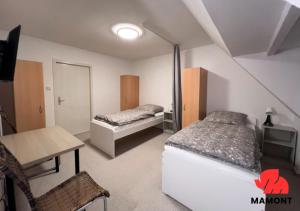 1 dormitorio con 2 camas, mesa y escritorio en Schöne und geräumige Monteurwohnung en Bremen