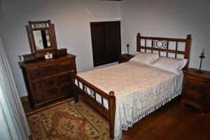 um quarto com uma cama, uma cómoda e um espelho em Casas do Cavaleiro Eira em Soajo