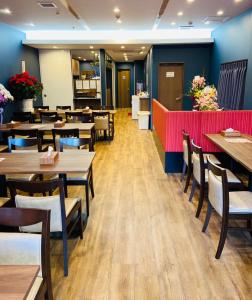 Hostel Wasabi Asakusa في طوكيو: غرفة طعام مع طاولات وكراسي خشبية