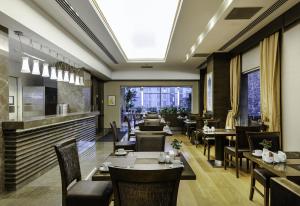 イスタンブールにあるレヴニ ホテル ＆ スパ スペシャル カテゴリーのテーブルと椅子のあるレストラン、バー