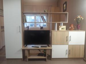 a living room with a tv and a desk with a tvictericter at Apartmani J&J in Šabac