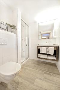 bagno bianco con servizi igienici e lavandino di Hotel Alpina Superior a Pettneu am Arlberg