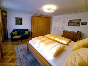 a bedroom with a large bed and a chair at ADORIS FERIENWOHNUNGEN auf der Lindauer Insel in Lindau