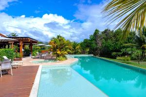 a swimming pool in a resort with chairs and trees at Apt 3 Quartos em Condo de Luxo in Mata de Sao Joao
