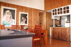 a kitchen and dining room with wood paneling and a table at Ruka Experience in Pucón