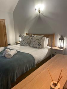 een slaapkamer met 2 bedden en een lampje aan de muur bij Enchanting Cottage for 4- Witchnest in Derbyshire, with EV point in Bonsall