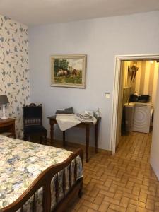 Cette chambre comprend un lit, une table et une fenêtre. dans l'établissement Le Voyageur, à Saint-Bonnet-Tronçais