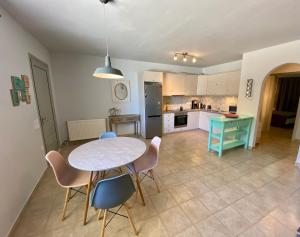 a kitchen and dining room with a table and chairs at CENTRAL APARTMENT PORTOHELI 1 in Porto Heli