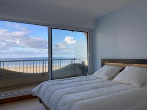 - une chambre avec une grande fenêtre donnant sur la plage dans l'établissement 471 - Appartement T2 avec terrasse pleine vue mer, à Erquy