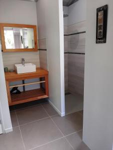 un bagno con lavandino e doccia di Caraïbes Cottages Corail piscine privée a 900m de la plage de Grande Anse a Deshaies