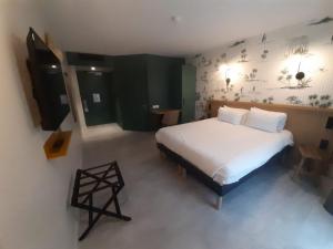 een slaapkamer met een groot bed met witte lakens en kussens bij L'Escale Marine, The Originals Relais in Crozon