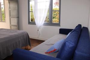een woonkamer met een blauwe bank en een raam bij 480 - Maison de pêcheur à 50m de la Plage de Caroual 
