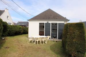 een tafel en stoelen in de tuin van een huis bij 480 - Maison de pêcheur à 50m de la Plage de Caroual 