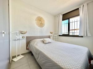 ein weißes Schlafzimmer mit einem Bett und einem Fenster in der Unterkunft Apartment VISTA BAHIA 23 -3 SEA VIEW Empuriabrava in Empuriabrava