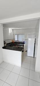 a white kitchen with a refrigerator and a counter at Casa em Caldas Novas in Caldas Novas