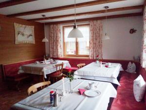 two tables in a restaurant with white table cloths at Frühstückspension Rüf in Au im Bregenzerwald