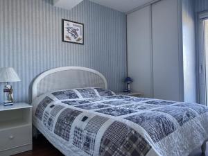 1 dormitorio con 1 cama con edredón azul y blanco en 505 - A ERQUY, située en bordure de la plage du centre, à 800m des commerces, en Erquy
