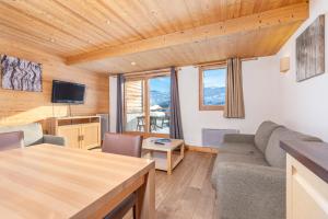 un soggiorno con un divano e un tavolo di Résidence Les Portes du Grand Massif - Flaine a Flaine