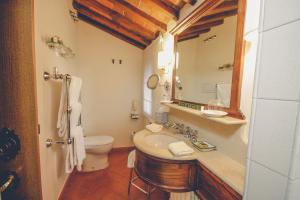 bagno con lavandino, servizi igienici e specchio di Capannelle Wine Resort a Gaiole in Chianti