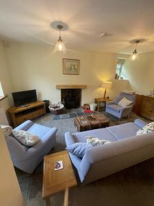 een woonkamer met 2 banken en een open haard bij Enchanting Cottage for 4- Witchnest in Derbyshire, with EV point in Bonsall