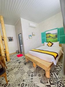 - une chambre avec un grand lit et un banc en bois dans l'établissement Ninh Chu 2 Hotel, à Phan Rang