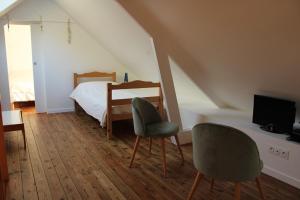 um quarto com uma cama e 2 cadeiras e uma televisão em 503 - Belle maison à Erquy à proximité du port et face à la plage em Erquy