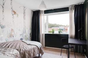 1 dormitorio con cama, escritorio y ventana en Nyköping Villa: Serene & Stylish en Nyköping