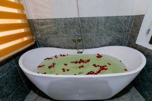Tam Coc Green Mountain Homestay في نينه بينه: حوض استحمام أبيض وديكورات حمراء فيه