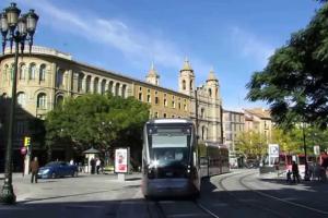 un autobús conduciendo por una calle frente a un edificio en Loft LVU en Zaragoza, en Zaragoza