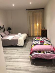 1 dormitorio con 2 camas y ventana en Loft LVU en Zaragoza, en Zaragoza