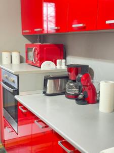a kitchen with red cabinets and a red mixer on a counter at RED Dhomes . Near Nymphaea in Oradea