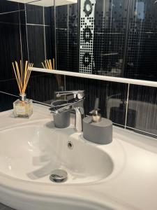 a white sink in a bathroom with a window at RED Dhomes . Near Nymphaea in Oradea