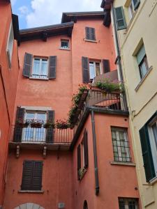 an orange building with flowers on a balcony at Il Cortiletto- Le Piazze in Brescia +3 photos