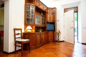 a kitchen with wooden cabinets and a table and a chair at Casa degli Affreschi Tuscany in San Rocco a Pilli