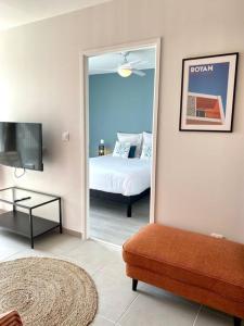 Zimmer mit einem Schlafzimmer mit einem Bett und einem Spiegel in der Unterkunft Confortable appt proche plage Pontaillac à Royan in Royan