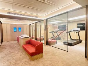 a room with a red chair and a treadmill at Intercity Shanghai Hongqiao Airport in Shanghai