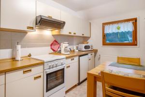 eine Küche mit weißen Geräten und einem Holztisch in der Unterkunft Haus Johanna in Todtmoos
