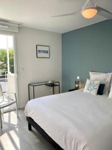 ein Schlafzimmer mit einem großen weißen Bett und einem Fenster in der Unterkunft Confortable appt proche plage Pontaillac à Royan in Royan