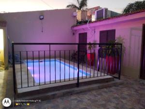 una casa púrpura con piscina frente a ella en Casa la bendecida II en Santiago del Estero