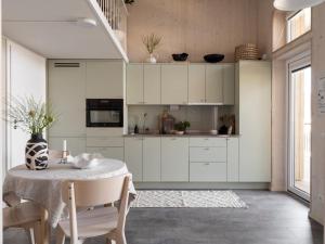 a kitchen with white cabinets and a table at Waterfront Cabins in Gothenburg