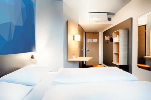 2 Betten in einem Hotelzimmer mit Bad in der Unterkunft B&B Hotel Frankfurt-Airport in Frankfurt am Main