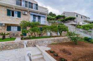 an apartment building with stairs and a yard with trees at Apartments Lena & Lara in Dubrovnik